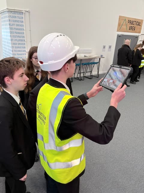 Students at a construction academy using a tablet